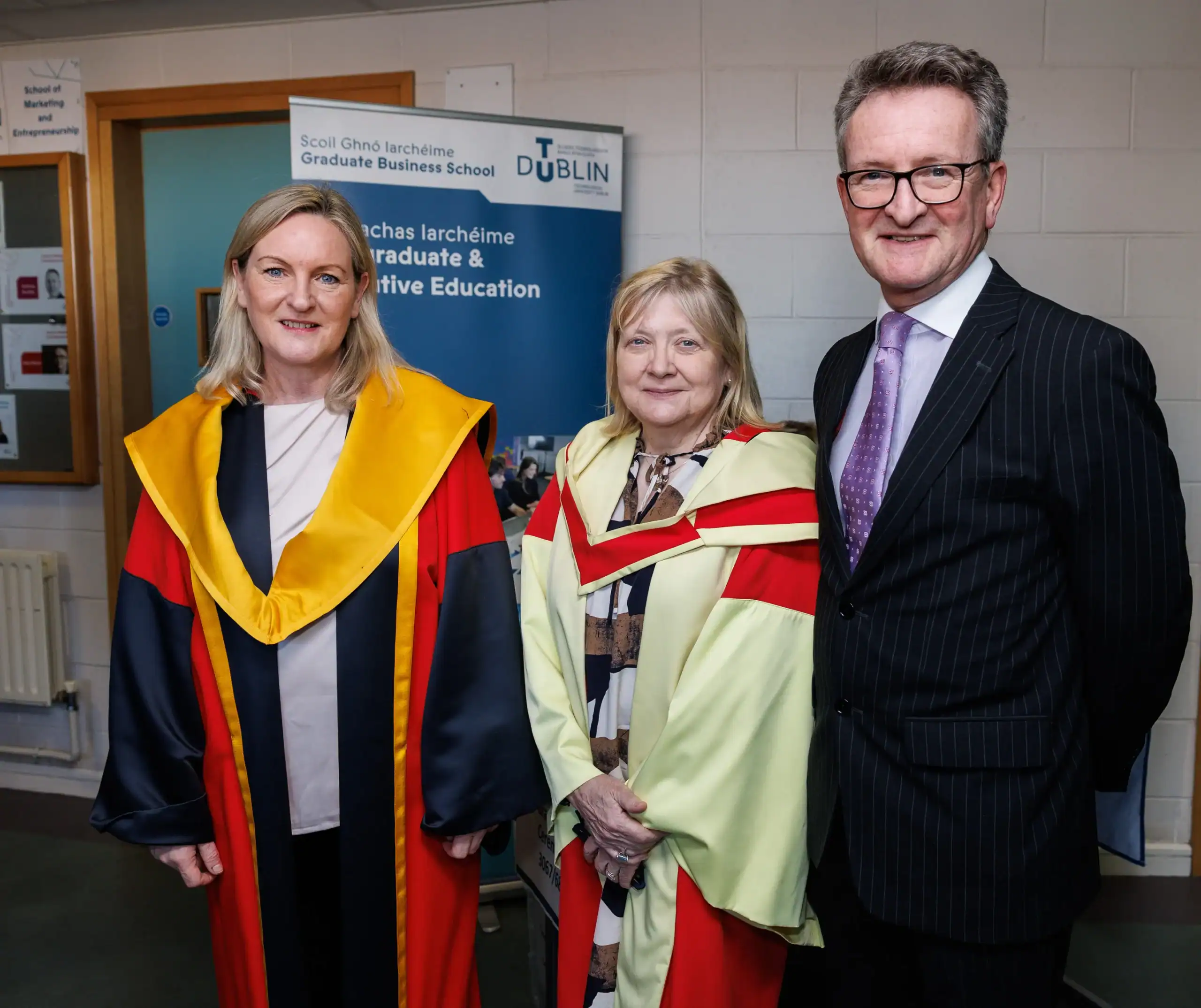 Three individuals in academic regalia
