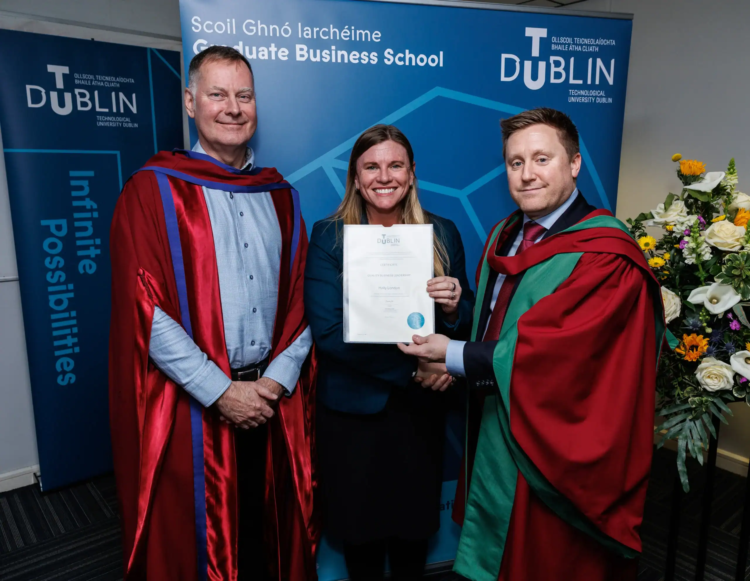 Graduation ceremony with three individuals