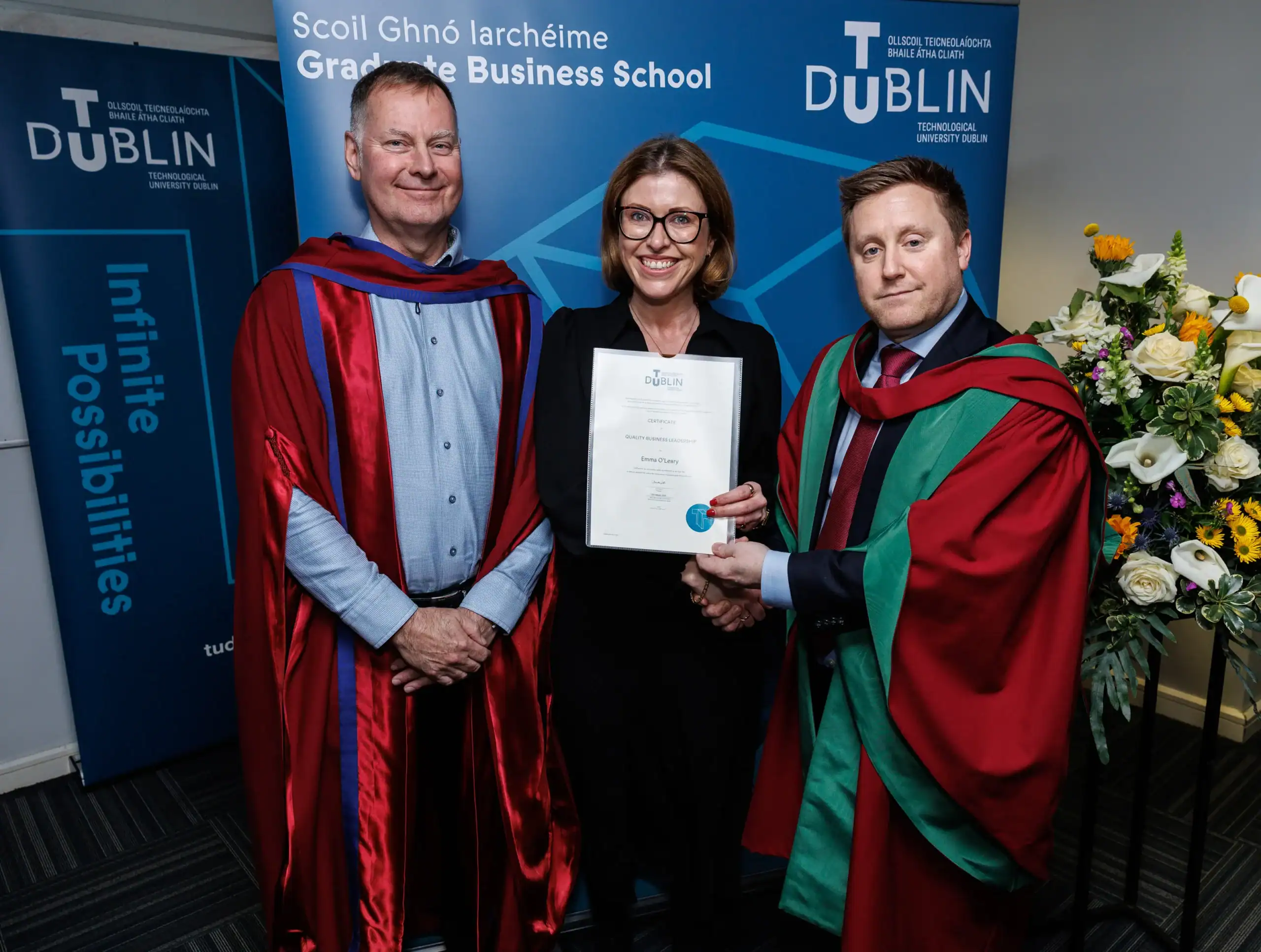 Graduation ceremony with three individuals