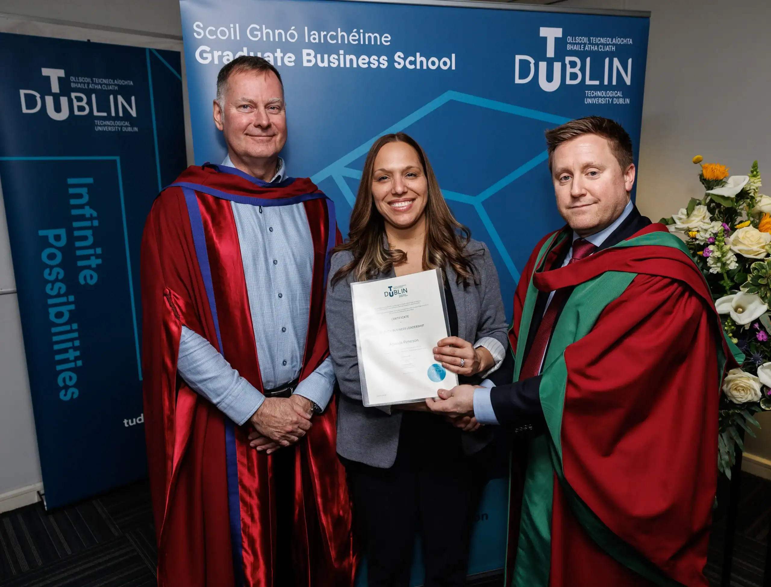 Graduation ceremony with three individuals